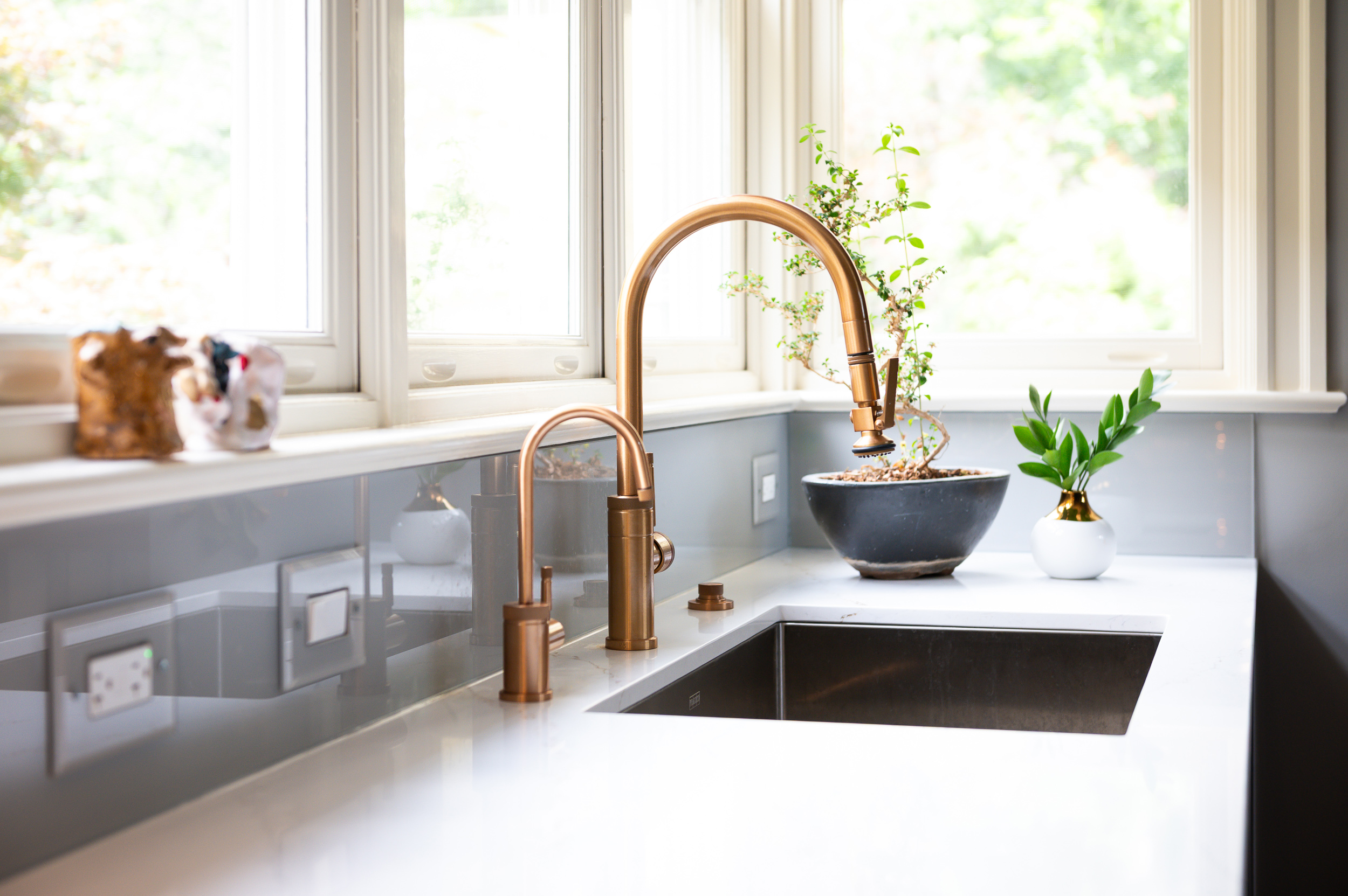 Sink wall with brass faucet and window light