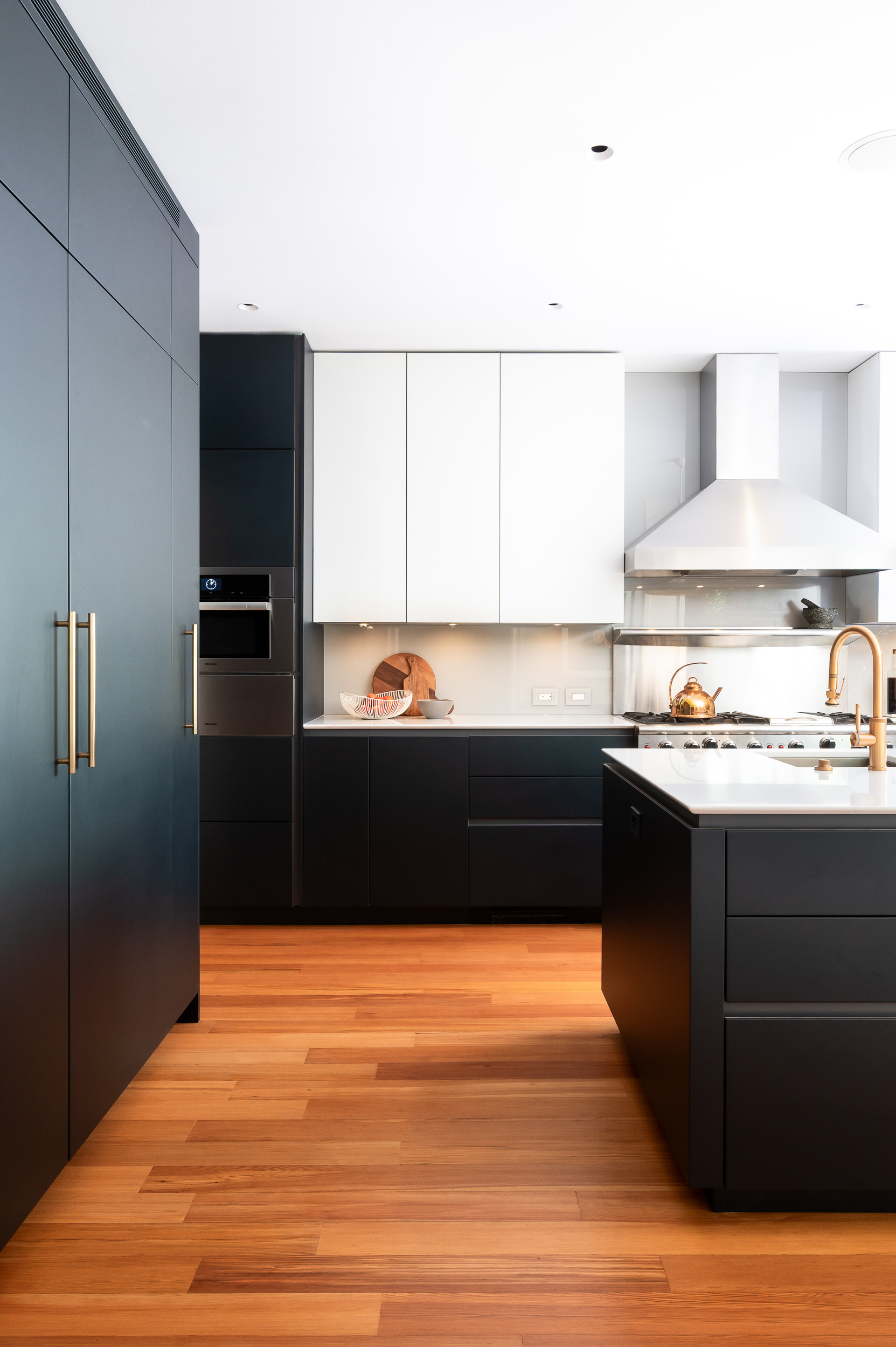 Dark blue kitchen cabinetry and integrated appliances